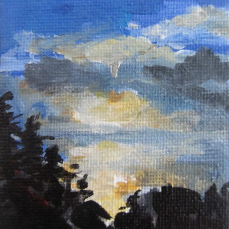 Abendhimmel mit Wolken über dunklen Silhouetten von Bäumen.