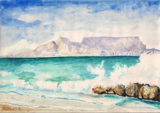 Cape Town Wellen brechen an einem Strand mit Blick auf Tafelberg und blauem Himmel.