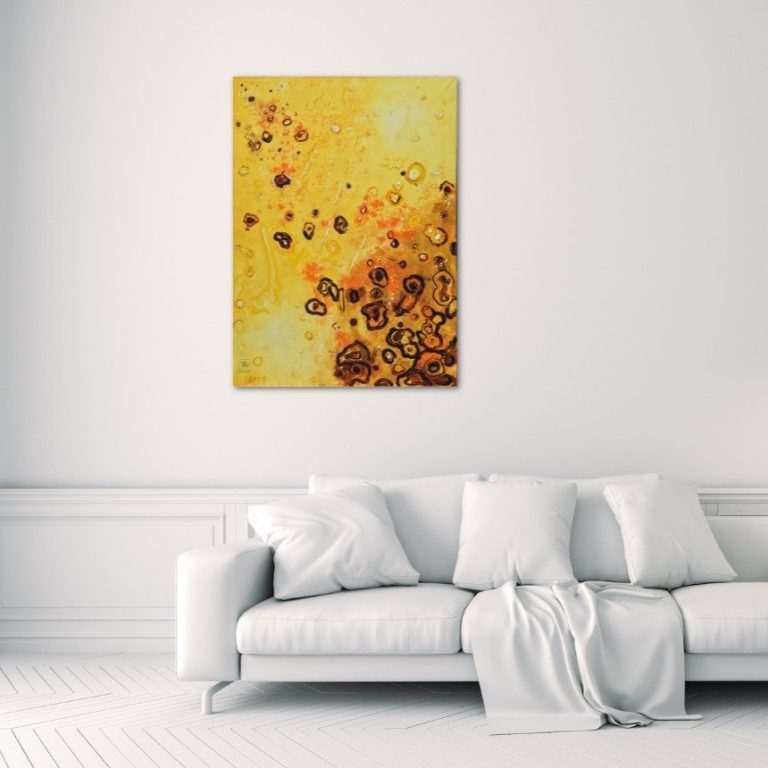 sun spots Abstrakte Kunst in Gelb- und Orangetönen von Herbert Wiedergut, präsentiert an einer weißen Wand über einem Sofa.