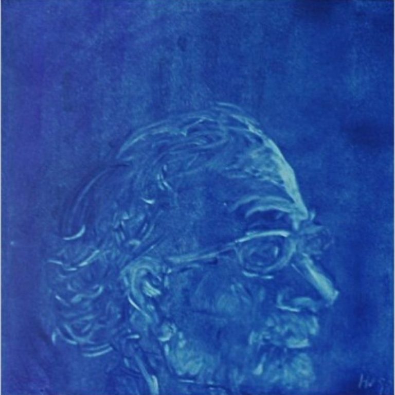 Porträt eines  Mannes in blauem Hintergrund, mit Brille und grauem Haar.